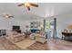 Spacious living room featuring soft neutral furniture, two ceiling fans, and wood flooring at 1021 Dimmocks Mill Rd, Hillsborough, NC 27278