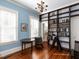 Blue-walled library with built-in bookshelves and hardwood floors at 1208 College Pl, Raleigh, NC 27605