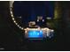Aerial view of the lighted backyard, featuring an in-ground pool and patio at 60 Citori Ct, Pittsboro, NC 27312