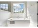 Luxurious bathroom with freestanding tub, large window, and white walls at 60 Citori Ct, Pittsboro, NC 27312