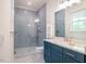 Modern bathroom with a glass-enclosed shower, blue cabinets, and quartz countertops at 60 Citori Ct, Pittsboro, NC 27312