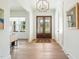 Bright and airy foyer featuring hardwood floors, a decorative chandelier, and double front doors at 60 Citori Ct, Pittsboro, NC 27312