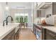 Modern kitchen with stainless steel appliances, an island sink, and an adjacent dining area at 60 Citori Ct, Pittsboro, NC 27312