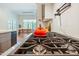 Close-up of a modern gas range in a stylish kitchen with a view to the dining area beyond at 60 Citori Ct, Pittsboro, NC 27312
