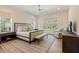 Bright main bedroom with large windows, neutral decor, and hardwood floors at 60 Citori Ct, Pittsboro, NC 27312