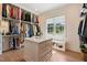 Spacious walk-in closet with custom shelving, island with drawers, and a window seat at 60 Citori Ct, Pittsboro, NC 27312