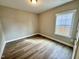 Spacious bedroom with wood-look flooring and large window at 1055 Fairhaven Dr # 56, Mebane, NC 27302