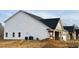 Newly constructed home showcasing a side view, featuring vinyl siding and a brick base at 1055 Fairhaven Dr # 56, Mebane, NC 27302