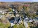 An aerial view captures a gray house with a modern architectural design and driveway amid colorful fall foliage at 701 Dartmouth Rd, Raleigh, NC 27609