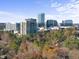 An aerial view features modern office buildings against a backdrop of vibrant foliage, highlighting the city's business district at 701 Dartmouth Rd, Raleigh, NC 27609