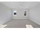 Bright bedroom with two windows, neutral carpet, ceiling fan, and white trim at 701 Dartmouth Rd, Raleigh, NC 27609