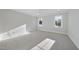 Bright bedroom with two windows, neutral carpet, ceiling fan, and white trim at 701 Dartmouth Rd, Raleigh, NC 27609