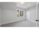 Bright bedroom featuring a window, neutral carpet, and white trim at 701 Dartmouth Rd, Raleigh, NC 27609