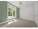 Bright bedroom with neutral carpet, large window, modern lighting, and fresh white trim at 701 Dartmouth Rd, Raleigh, NC 27609