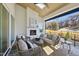 Inviting covered patio with a cozy fireplace, comfortable seating, and a ceiling fan, ideal for outdoor relaxation at 701 Dartmouth Rd, Raleigh, NC 27609