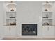 A modern fireplace with marble surround and custom built-in shelving on both sides at 701 Dartmouth Rd, Raleigh, NC 27609