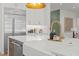 Close-up of a kitchen island featuring a white countertop, a farmhouse sink, and a modern gold faucet with dispenser at 701 Dartmouth Rd, Raleigh, NC 27609