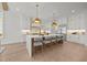Open-concept kitchen with white cabinetry, a large center island with seating, and modern pendant lighting at 701 Dartmouth Rd, Raleigh, NC 27609