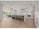 Expansive kitchen boasts white cabinets, an oversized island with seating, and large windows for abundant natural light at 701 Dartmouth Rd, Raleigh, NC 27609