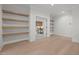 Office space with custom built-in shelving, light wood floors, and a view into the dining area at 701 Dartmouth Rd, Raleigh, NC 27609