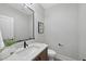 Elegant powder room with marble countertop, modern black faucet, and stylish mirror, enhancing the home's sophisticated design at 701 Dartmouth Rd, Raleigh, NC 27609