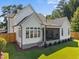 The rear exterior shows patio and well manicured lawn surrounded by lush green trees at 701 Dartmouth Rd, Raleigh, NC 27609