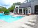 Community pool area features lounge chairs, lush landscaping, and an outdoor shower at 7250 Nc 751 Hwy # 2101, Durham, NC 27707
