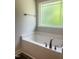 Cozy bathroom with a deep soaking tub and a window for natural light at 321 Hopewell Branch Ct, Smithfield, NC 27577