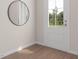 Hallway with a round mirror and a white door with a large window overlooking the front yard at 1206 Holding Village Way, Wake Forest, NC 27587
