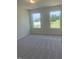 A bright bedroom with neutral carpet and two windows at 1528 Maelyn Way, Fuquay Varina, NC 27526