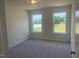 Light-filled bedroom with carpeted floors and views of the green backyard at 1528 Maelyn Way, Fuquay Varina, NC 27526