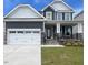 Charming two-story home featuring a large garage and stone accents at 1528 Maelyn Way, Fuquay Varina, NC 27526