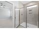 Modern bathroom featuring a tiled shower with glass enclosure and access to the bedroom at 240 Sequoia Dr, Louisburg, NC 27549