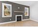 Close up of living room area with decorative fireplace and mantle between two bright windows at 240 Sequoia Dr, Louisburg, NC 27549