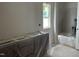 Unfinished bathroom shows white walls, window, cabinet and tub still wrapped in protective plastic at 2408 Adrift Road, Fuquay Varina, NC 27526