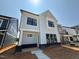 Charming two-story home featuring a light blue facade, black framed windows and modern architectural details at 2408 Adrift Road, Fuquay Varina, NC 27526