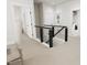 Upstairs hallway with black horizontal railing and view of the laundry room at 2408 Adrift Road, Fuquay Varina, NC 27526
