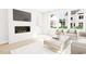 Modern living room features bright natural light, a fireplace, light wood floors, and neutral decor at 2408 Adrift Road, Fuquay Varina, NC 27526