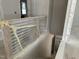 The new home interior showcases an unfinished staircase with protective plastic and white walls at 2408 Adrift Road, Fuquay Varina, NC 27526