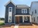 Charming two-story home featuring dark siding, white trim, and a welcoming front porch at 2412 Adrift Road, Fuquay Varina, NC 27526