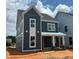 New two-story home featuring blue siding, a covered porch with stone accents and bright white window frames at 2412 Adrift Road, Fuquay Varina, NC 27526