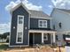 Stylish two-story home featuring modern vertical siding, white trim, and a welcoming front porch, still under construction at 2412 Adrift Road, Fuquay Varina, NC 27526