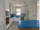 Bright kitchen featuring custom white cabinetry, a farmhouse sink, and an island with room for seating at 2412 Adrift Road, Fuquay Varina, NC 27526