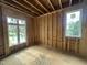 Unfinished bedroom framed with two large windows providing natural light and views of the neighborhood at 3301 Dell Dr, Raleigh, NC 27609