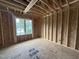 New construction bedroom featuring stud framing, a window, and wood flooring at 3301 Dell Dr, Raleigh, NC 27609