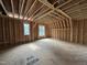New construction bonus room featuring stud framing, windows, and wood flooring at 3301 Dell Dr, Raleigh, NC 27609