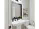 Elegant powder room featuring a pedestal sink, dark accents, and stylish decor at 2400 Adrift Rd, Fuquay Varina, NC 27526