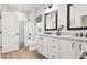 Bathroom with dual vanity, tub/shower, and sleek modern fixtures at 2400 Adrift Rd, Fuquay Varina, NC 27526