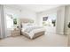 Bright bedroom featuring two large windows, a neutral color scheme, and a tufted headboard at 2400 Adrift Rd, Fuquay Varina, NC 27526