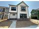 Modern two-story home featuring white siding, black trim, and a stone-accented base at 2400 Adrift Rd, Fuquay Varina, NC 27526